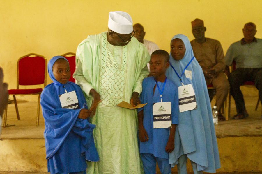 A community leader presenting an award to student participants